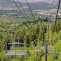 Square Chairlifts against green trees and mountain with hiking trails at off season