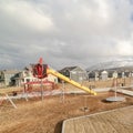 Square Childrens playground against snow capped mountain and cloudy sky in winter