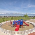 Square Childrens playground ovelooking homes lake and snow peaked mountain under sky