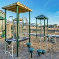 Square Childrens playground in the sunny neighborhood overlooking houses and blue sky