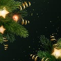Square Christmas background design with fir branches, glowing stars, gold serpentines and luminous light bulbs. Dark Royalty Free Stock Photo