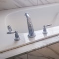 Square Close up of built in rectangular bathtub with stainless steel faucet and handles Royalty Free Stock Photo