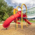 Square Close up view of the colorful playground with red closed tube slide at a park