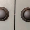 Square Close up view of matte black round door knobs of a gray bedroom double door