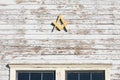 Square and compasses symbol on old worn white wooden building wall