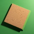 Square cork tile on a green surface, creating a distinct contrast Royalty Free Stock Photo