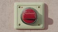 A square, cream-colored emergency stop button with a prominent red circular push Royalty Free Stock Photo