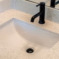 Square crop Bathroom white countertop with single basin undermount sink and black faucet