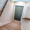 Square crop Carpeted U shaped staircase that leads down to the basement door of a home Royalty Free Stock Photo