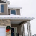 Square crop Home facade with festive Christmas wreaths and colorful string lights in winter