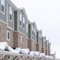 Square crop Townhome facade with snowy gabled roof at the entrance in winter