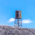 Square Cylindrical water storage tank container on a steel tower at Wasatch Mountains Royalty Free Stock Photo