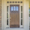 Square Dark wooden front door with transom window and side panels Royalty Free Stock Photo