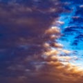 Square Defocussed view of a vast blue sky filled with puffy dark clouds at sunset Royalty Free Stock Photo