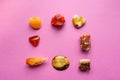 A square of different minerals on pink background. Spiritual amber, calcite, Aragonite, Simbercite, Jasper, Tiger`s eye