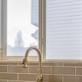 Square Double sink and faucet of a kitchen with view of outdoors through the window Royalty Free Stock Photo