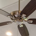 Square Electrical fan with built in lights installed on decorative wooden ceiling beam