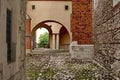 Square enclosed patio with arch and brick walls