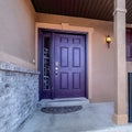 Square Entrance of home with stairs leading to porch and purple front door with wreath Royalty Free Stock Photo