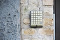 Square entrance old broken intercom buttons on brick wall Royalty Free Stock Photo