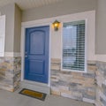 Square Exterior of a home with blue wooden front door and reflective glass windows