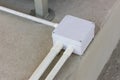 Square Flooring box with plastic pipes and electric cables. White electrical junction box and wires on the floor.  Installation of Royalty Free Stock Photo