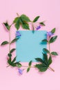 Square flower frame with turquoise sheet on pink background.