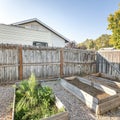 Square frame Backyard with raised bed garden and wooden fence and gate Royalty Free Stock Photo