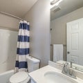 Square frame Bathroom interior with vanity sink and bathtub shower combo with striped shower curtain Royalty Free Stock Photo