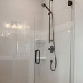 Square frame Bathroom shower stall with half glass enclosure adjacent to built in bathtub Royalty Free Stock Photo