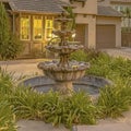 Square frame Beautiful tiered fountain at the garden of a home against sky with gray clouds Royalty Free Stock Photo