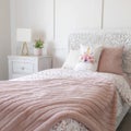 Square frame Bedroom interior with floral feminine beddings and decorative headboard on bed