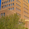 Square frame Building exterior with brick wall and rectangular windows against blue sky