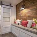 Square frame Built in banquette along the brown wood wall of a home with carpeted floor