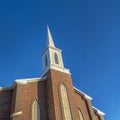 Square frame Church with classic red brick exterior wall and white steeple against blue sky Royalty Free Stock Photo