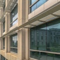 Square frame Close up of the glass windows and concrete exterior wall of a modern building Royalty Free Stock Photo