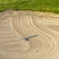 Square frame Close up of golf course sand bunker with a circular pattern created by the rake