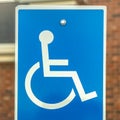 Square frame Close up of Handicapped Parking sign against blurred red brick wall of church Royalty Free Stock Photo