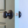 Square frame Close up of a round black door knob installed on a gray paneled interior door Royalty Free Stock Photo