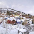 Square frame Colorful homes and scenic hills blanketed with white snow during winter season