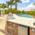 Square frame Day shot of a wonder California home with a large pool and counter space for a barbeque on a bright sunny Royalty Free Stock Photo