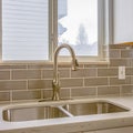 Square frame Double sink and faucet of a kitchen with view of outdoors through the window Royalty Free Stock Photo