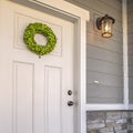 Square frame Facade of a home with a simple wreath hanging on the white wooden door Royalty Free Stock Photo