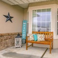 Square frame Facade of a home with a wooden bench on the welcoming front porch