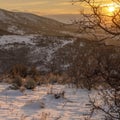 Square frame Fresh snow covering the landscape against golden sun and cloudy sky at sunset