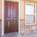 Square frame Front door exterior of a house with half stone and wooden wall