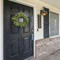 Square frame Front door exterior with leaf wreath, wooden white railings and wall bricks