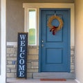 Square frame Golden wreath on the blue front door of a house with concrete and stone wall Royalty Free Stock Photo