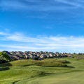 Square frame Golf course and homes under blue sky with clouds viewed on a sunny day Royalty Free Stock Photo