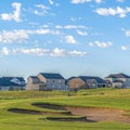 Square frame Golf course and houses with distant mountain and blue sky view on a sunny day Royalty Free Stock Photo